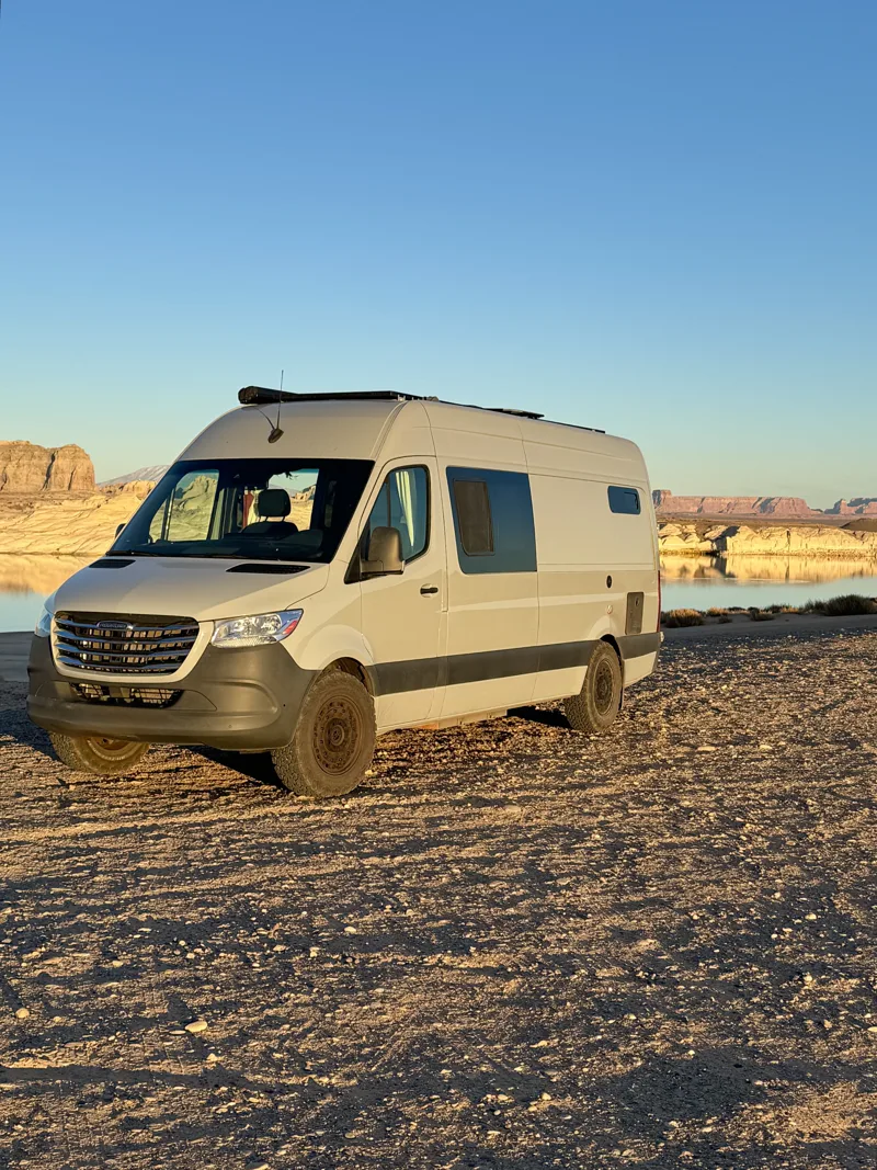 Pebbles parked beside water and sandstone formations