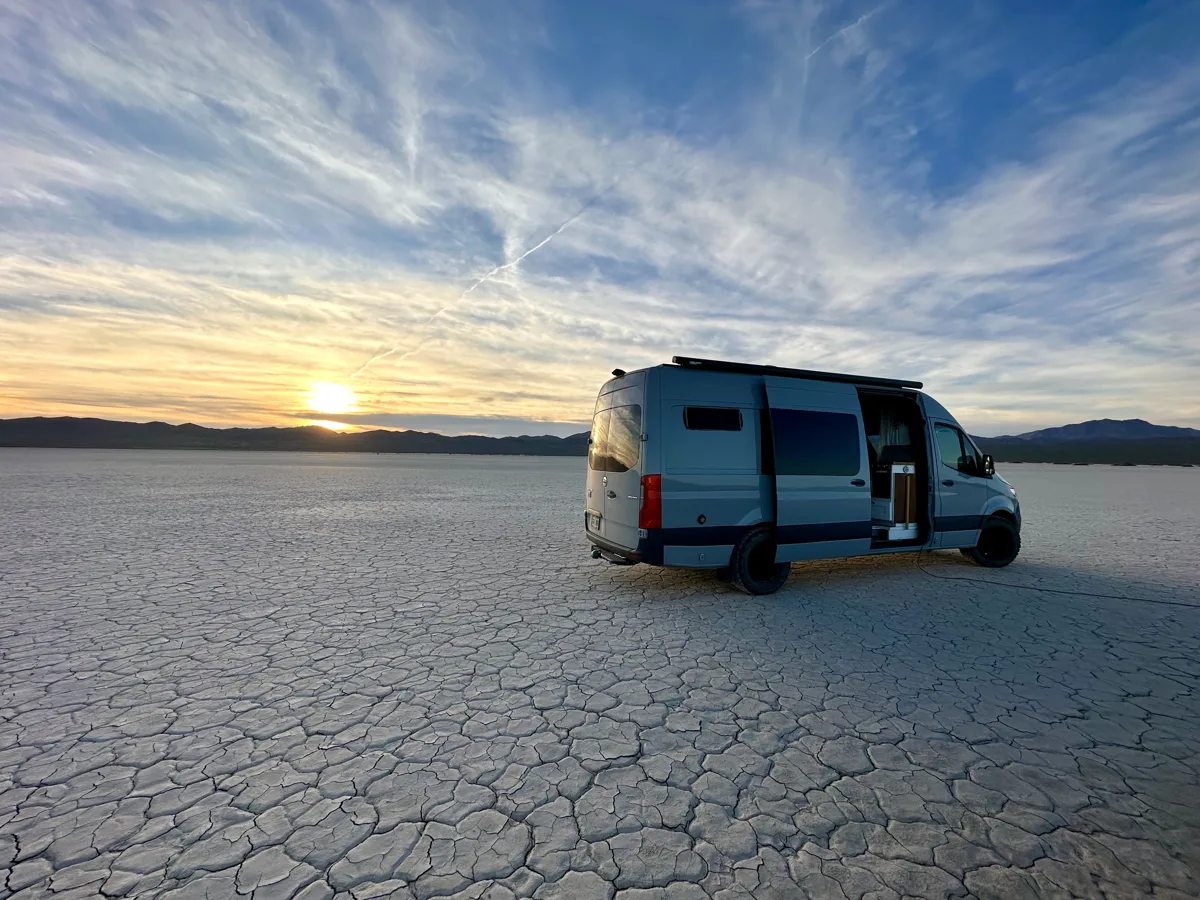 Pebbles camped on salt flats beneath a wide evening sky