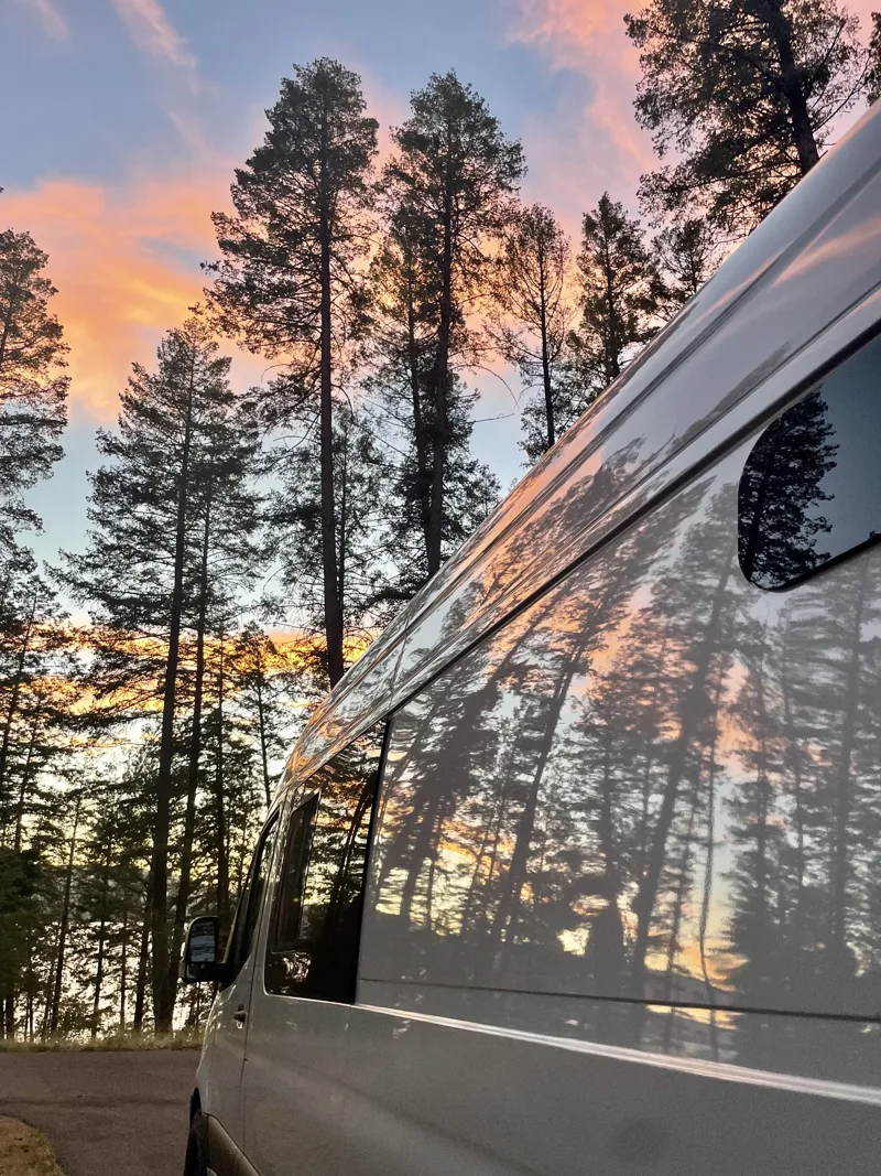 Sunset and trees reflected in Pebbles’ side windows