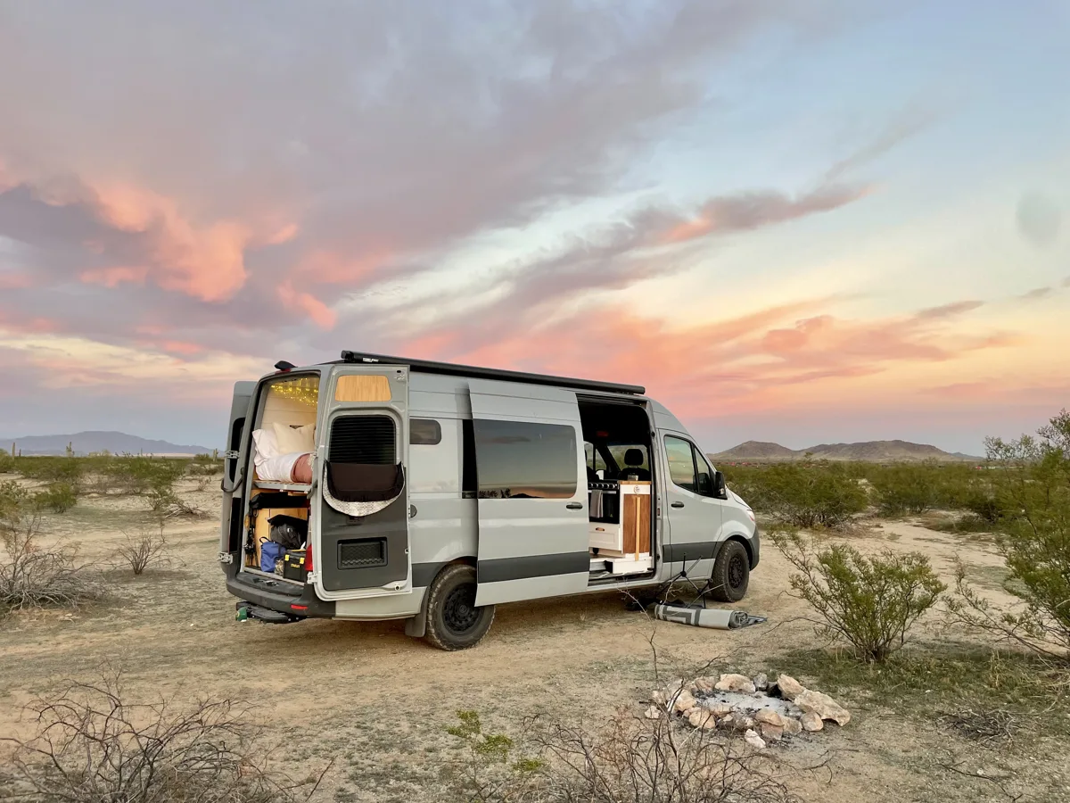 Pebbles with the doors open at a desert sunset campsite