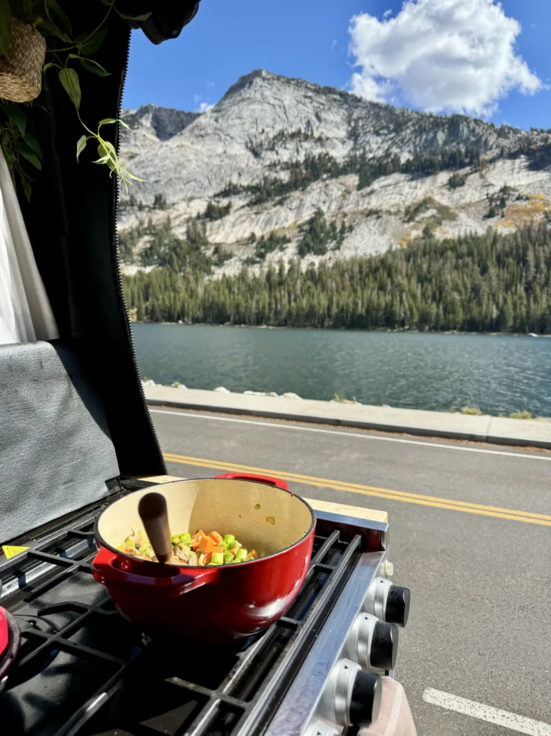 Cooking beside a mountain lake with the van door open