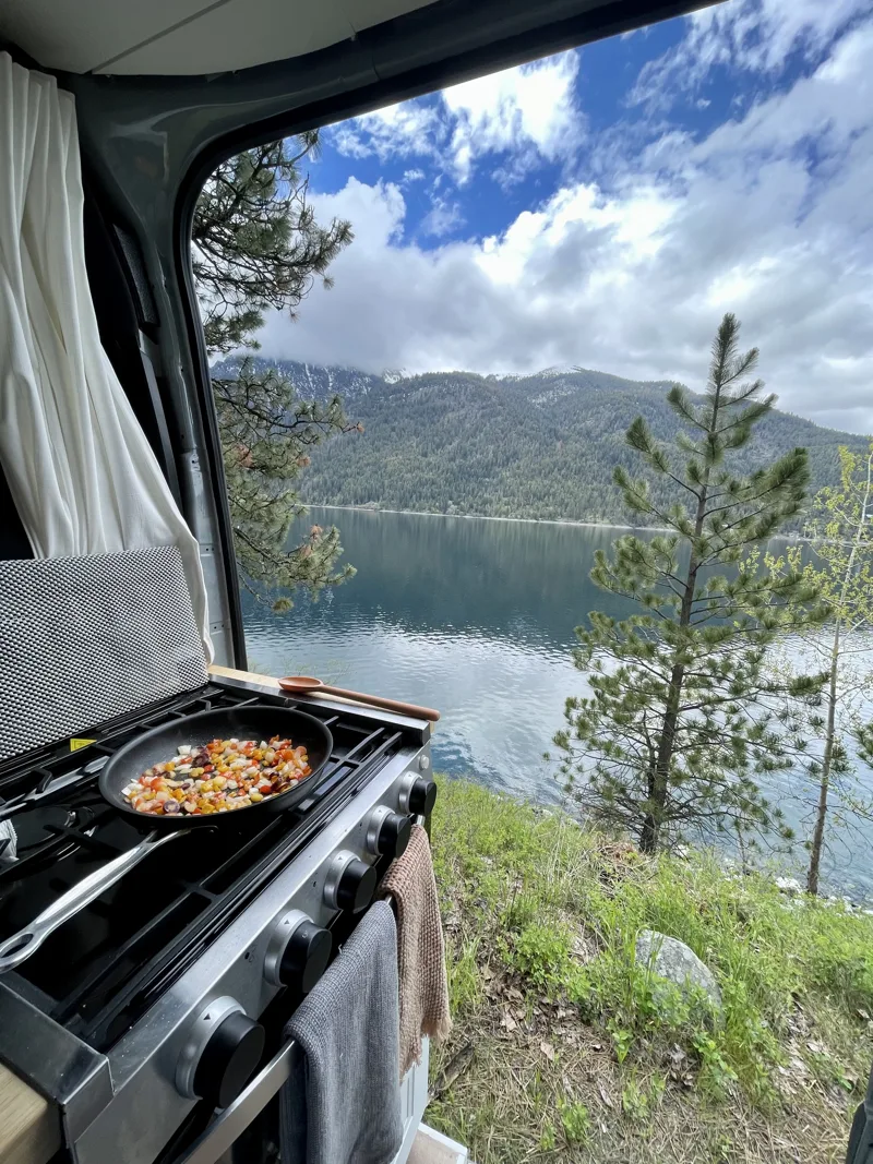 Meal cooking on the stovetop overlooking a lake