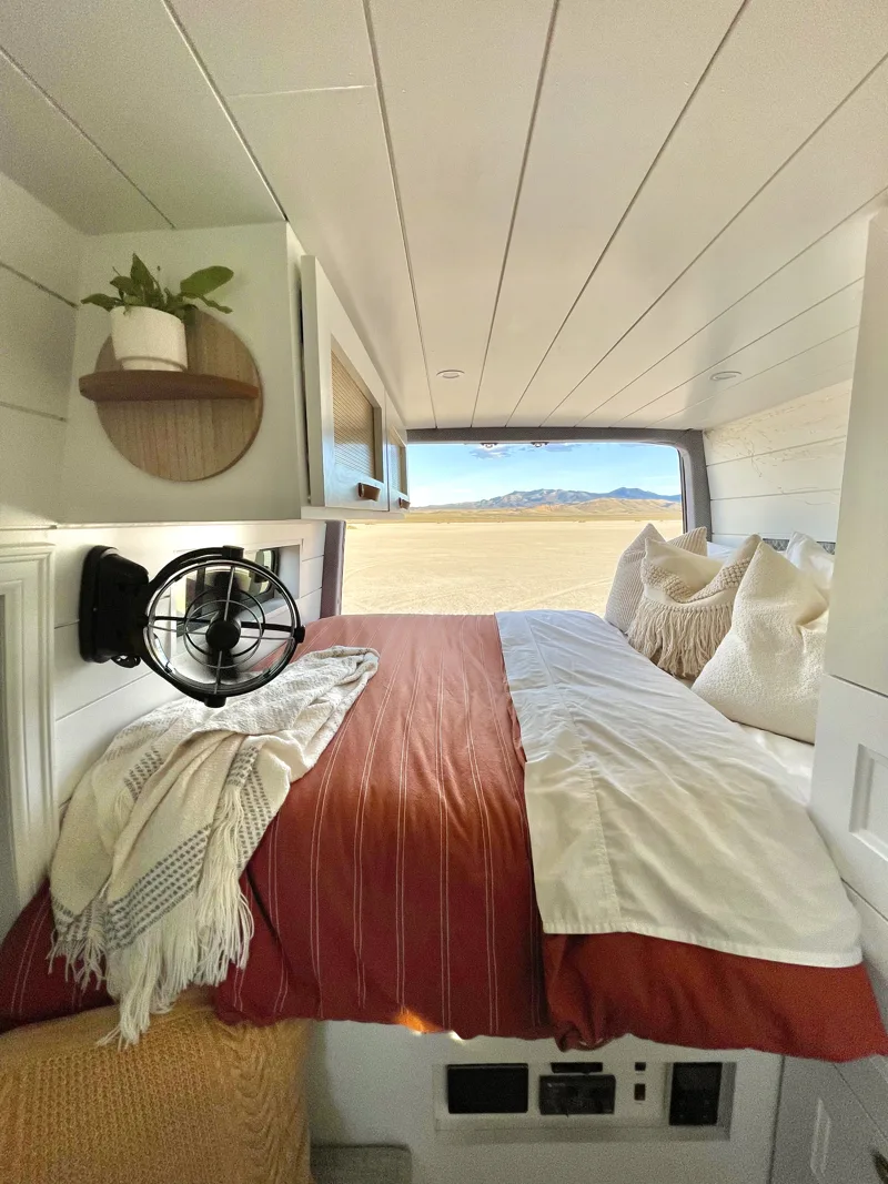 Custom bed beneath the overhead cabinets with a desert view