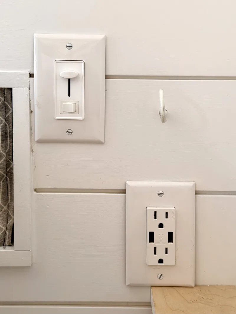 Charging outlets and light switch beside the bed
